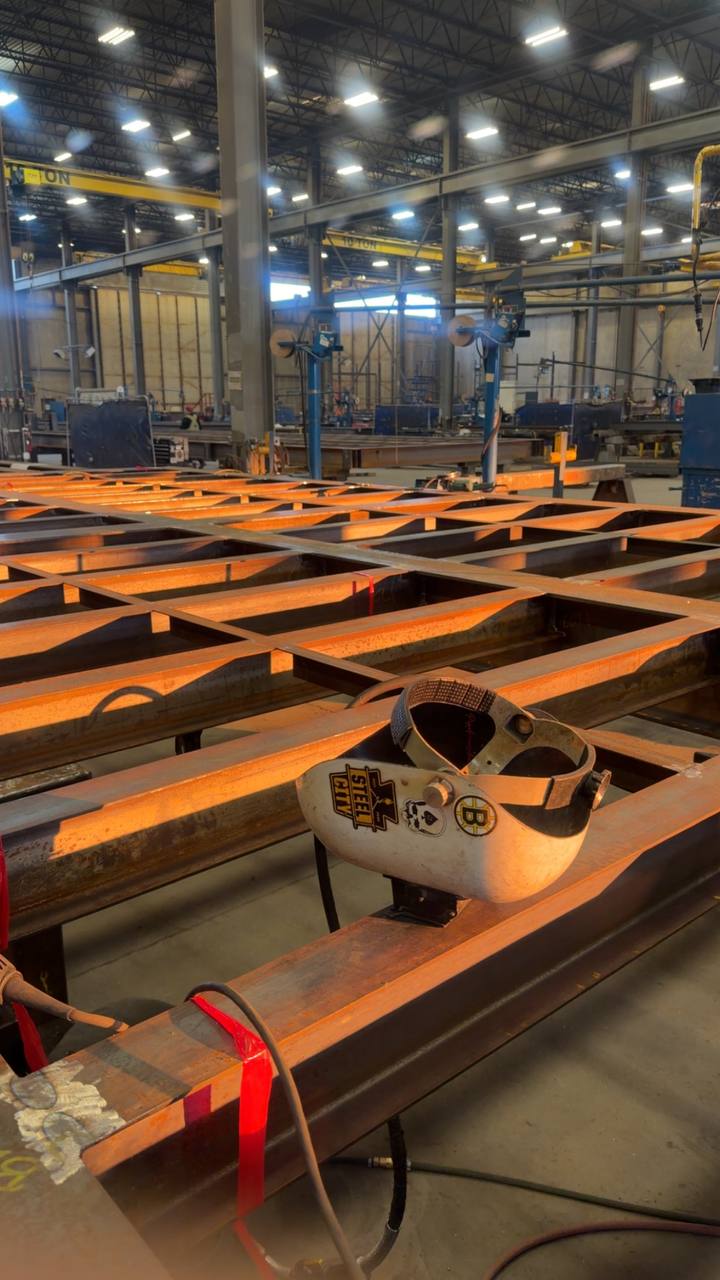 Welder's Steel City helmet on orange structural steel beams, ready for the next job